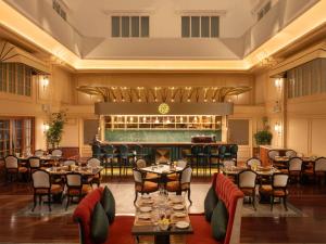 a restaurant with tables and chairs and a bar at Hotel de l'Opera Hanoi - MGallery in Hanoi