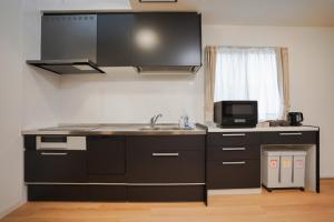 a kitchen with a sink and a microwave at Laon Inn Plus Miyakojima in Miyako-jima +9 photos
