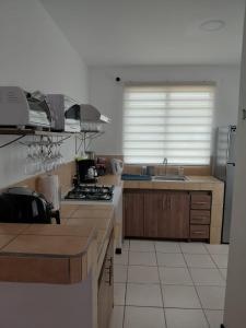 a kitchen with a sink and a stove top oven at Sunset House Herradura in Herradura