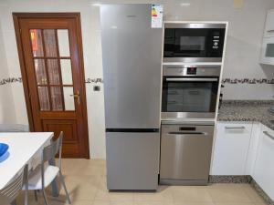 a kitchen with a refrigerator and a microwave at Casa-Nova Centro in Sarria