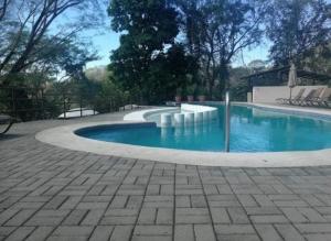 a swimming pool with blue water in a yard at Sunset House Herradura in Herradura