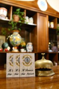 a table with a tea kettle and a sign on it at Hotel Il Barocco in Ragusa