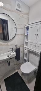 a bathroom with a toilet and a sink and a mirror at Private Studio Suite, 24h Self Check-in in Luton