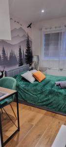 a bedroom with a large bed with a green comforter at Private Studio Suite, 24h Self Check-in in Luton