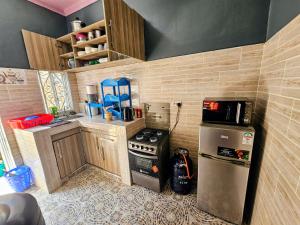 a small kitchen with a stove and a refrigerator at Deripacs Homes in Lodwar