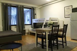 a living room with a table and chairs and a piano at Vandrarhemmet Eken in Eksjö