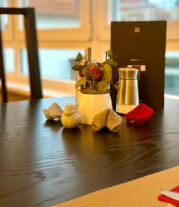 a wooden table with a vase of flowers and a centerpiece at Hotel Friedrichstraße in Lampertheim