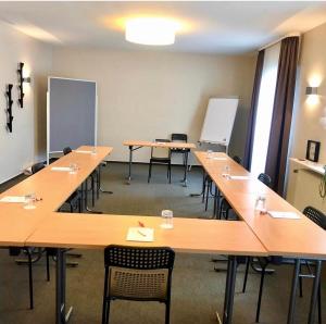 a classroom with tables and chairs in a room at Hotel Friedrichstraße in Lampertheim