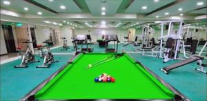 a pool table in a fitness room with machines at Birch Tower Condominium Malate in Sampong