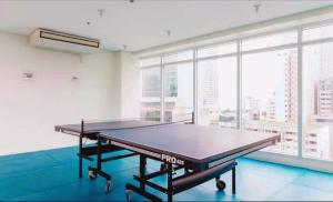 a ping pong table in a room with a large window at Birch Tower Condominium Malate in Sampong