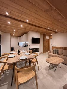 a living room with a table and chairs and a couch at Résidence Frond'Neige in Morzine