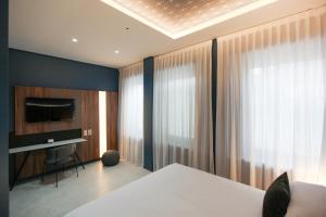a bedroom with a bed and a tv and curtains at The FLOOR in Milan