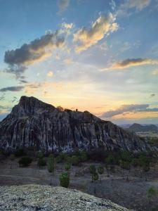 a rocky mountain with a sunset in the background at Abrigo de Montanha Quixadá in Quixadá