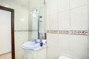 a white bathroom with a sink and a mirror at casa La cabaña Villa Palomino in Gáldar +25 photos