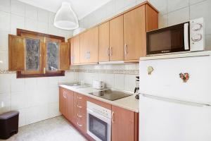 a kitchen with a white refrigerator and wooden cabinets at casa La cabaña Villa Palomino in Gáldar