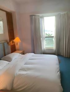 two beds in a hotel room with a window at 2BR Seaview Condo with Balcony, Riviera Bay Resort Melaka in Malacca +5 photos