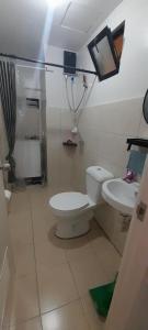 a bathroom with a toilet and a sink at Ubec Vacation Home - Royal Oceancrest Mactan Cebu Condominium in Cebu City +4 photos