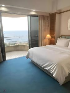a bedroom with a large bed and a balcony at 2BR Seaview Condo with Balcony at Riviera Bay Resort, Melaka in Malacca