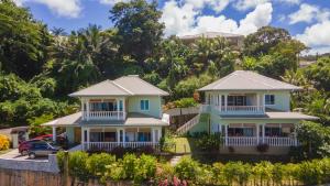 a house on the side of a hill with trees at TOP VIEW RETREAT SELFCATERING in Anse a La Mouche