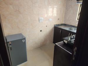 a small kitchen with a sink and a refrigerator at The Oasis in Ilorin