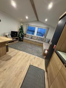 a living room with a couch and a christmas tree at The Ellerton at Eyemouth in Eyemouth