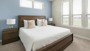 a bedroom with a bed with two night stands and two windows at Landing Incredible 1BD Pool Gym in Katy +32 photos