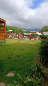 a yard with chairs and umbrellas and a building at Cabañas Biancomoro Olmue in Olmué
