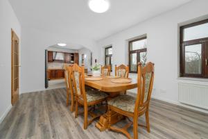 a dining room with a wooden table and chairs at Apartmán Regina in Liberec
