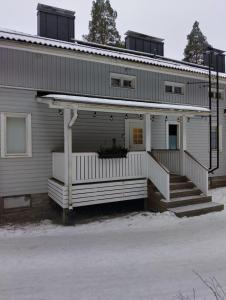 a white house with a porch and stairs on it at Navy Condo for 6, free parking in Turku