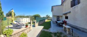 a backyard of a building with a table and chairs at Apartment Glavani with Pool in Barban +19 photos