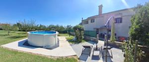a backyard with a hot tub and a house at Apartment Glavani with Pool in Barban