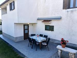 a patio with a table and chairs in front of a house at Apartment Glavani with Pool in Barban