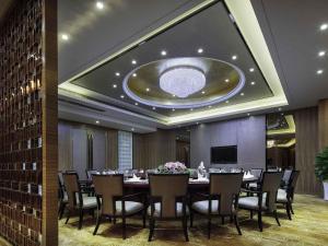a dining room with a long table and chairs at Pullman Anshan Time Square in Anshan