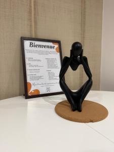 a statue of a person sitting next to a sign at L'écrin orange, Wifi et parking gratuit in Chalons en Champagne