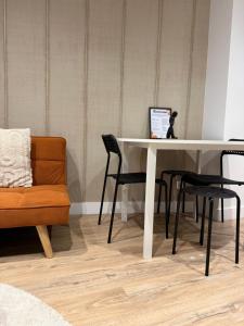 a white table with two chairs and a couch at L'écrin orange, Wifi et parking gratuit in Chalons en Champagne