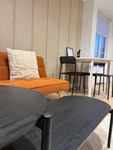 a living room with a couch and a table with a laptop at L'écrin orange, Wifi et parking gratuit in Chalons en Champagne