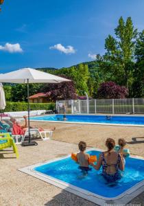 a group of children playing in a swimming pool at Camping l'Estela sur le GR70 in Le Monastier sur Gazeille