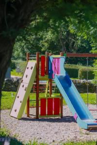 a playground with a slide in a park at Camping l'Estela sur le GR70 in Le Monastier sur Gazeille