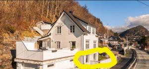 a white house with a yellow symbol in front of it at Salhusvegen in Bergen