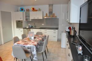a kitchen with a table and chairs and a kitchen with white cabinets at La cadole de Clem in Juliénas