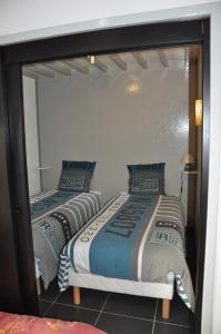 two beds in a room with a mirror at La cadole de Clem in Juliénas