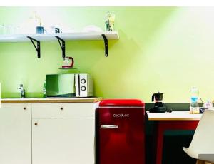 a red refrigerator in a kitchen next to a table at Mini alloggi alle terme in Abano Terme