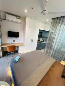 a bedroom with a bed and a desk with a computer at Landin2home studios in New Delhi