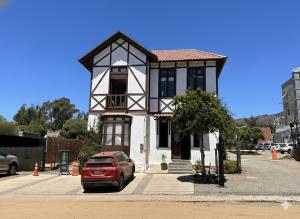 a red car parked in front of a building at La Casona Papudo in Papudo