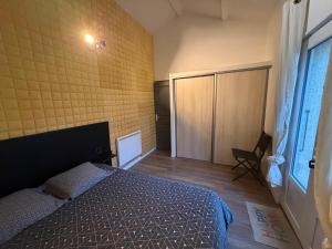 a bedroom with a bed and a yellow brick wall at Chambre indépendante 1 lit 2 pers maison calme in Romans-sur-Isère +4 photos