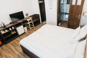 a bedroom with a white bed and a desk at Szende Vendégház in Villány