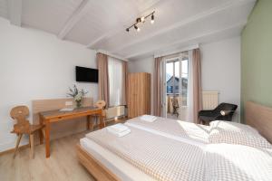 a bedroom with a large bed and a desk and a desk at Interlaken Apartments in Interlaken