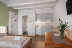 a living room with a table and a kitchen at Interlaken Apartments in Interlaken