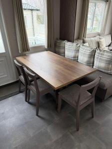 a wooden table and chairs in a living room with a couch at Paws A While in Mainsriddle +10 photos
