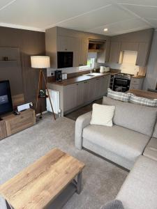 a living room with a couch and a kitchen at Paws A While in Mainsriddle